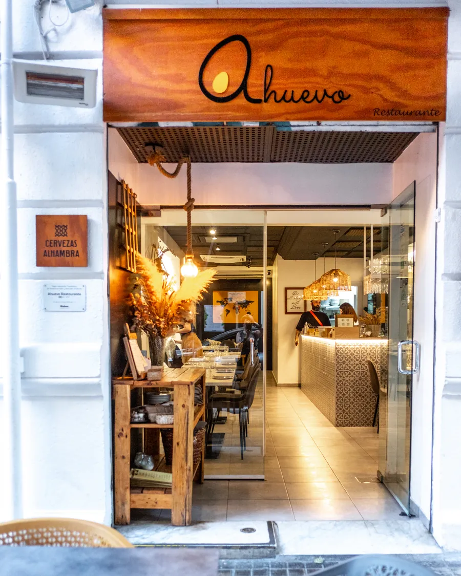 The door of A Huevo, with its wooden sign, and the dining room beyond