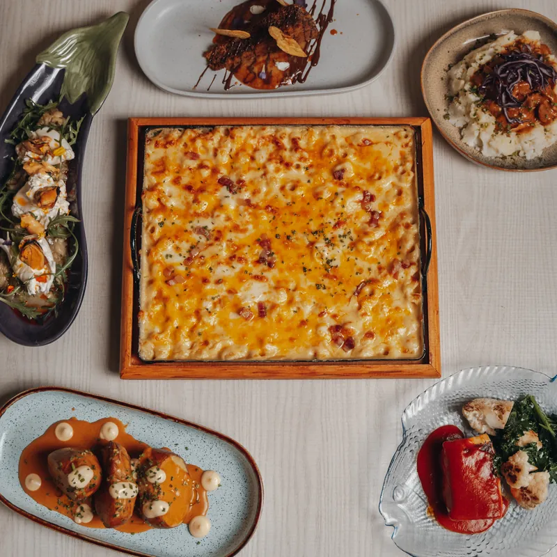 A table seen from above with mac and cheese, aubergine and several dishes to share