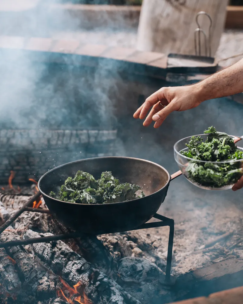 Kale en una sartén sobre la lumbre, en la huerta