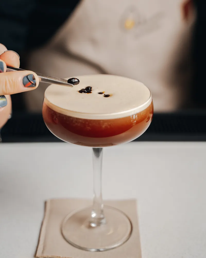 Se decora con unas pinzas un cóctel de café con espuma, en copa