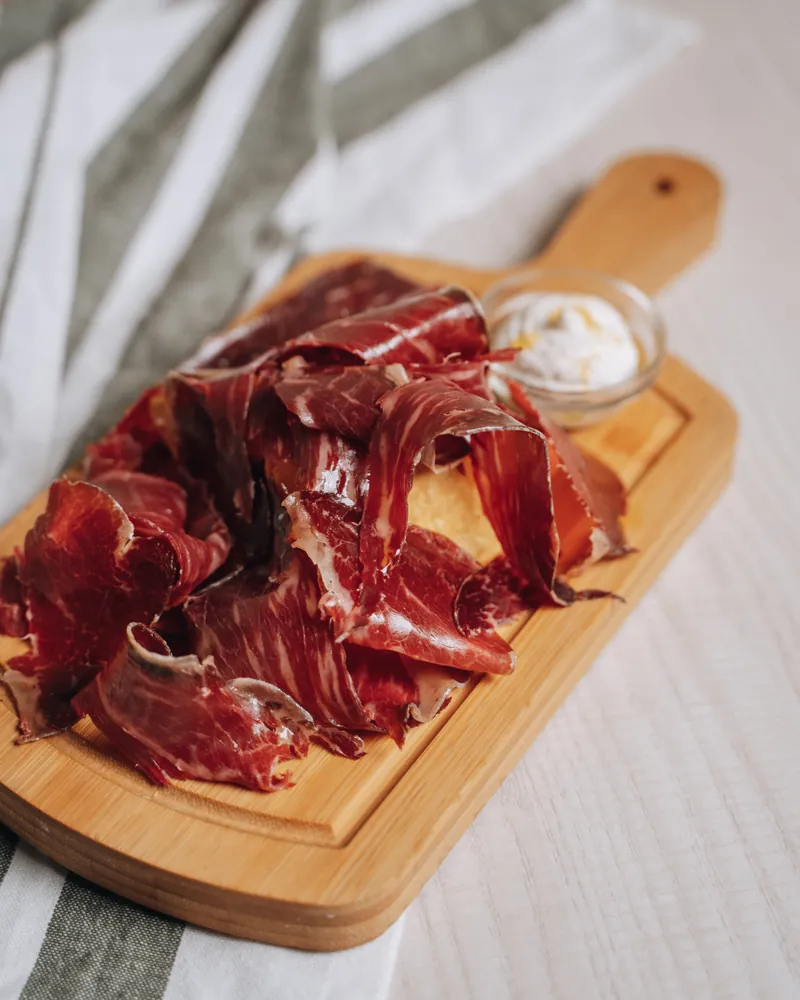 Hand-carved Ibérico ham on a wooden board